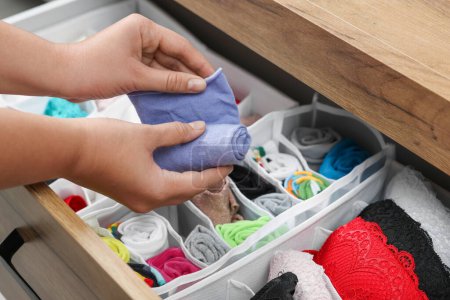 Photo for Woman rolling socks above organizers with underwear in drawer, closeup - Royalty Free Image