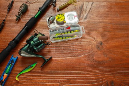 Photo for Fishing tackle on wooden table, above view. Space for text - Royalty Free Image