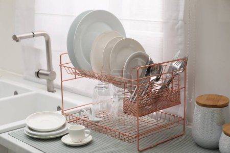 Photo for Drying rack with clean dishes on countertop near sink in kitchen - Royalty Free Image