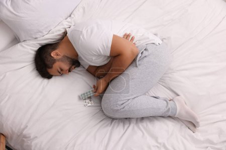 Foto de Hombre deprimido con antidepresivos en la cama, vista superior - Imagen libre de derechos