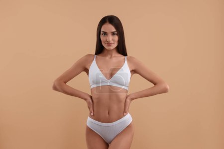 Photo for Young woman in stylish white bikini on beige background - Royalty Free Image