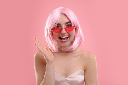 Pinkfarbener Look. Schöne Mädchen mit Perücke und heller Sonnenbrille auf farbigem Hintergrund