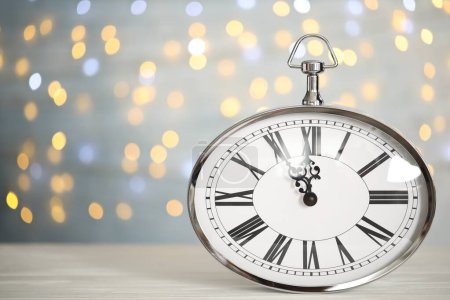 Photo for Clock showing five minutes until midnight on blurred background, space for text. New Year countdown - Royalty Free Image