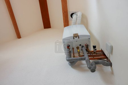 Modern gas boiler on white wall indoors, low angle view. Space for text