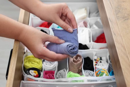 Photo for Woman rolling socks above organizers with underwear in drawer, closeup - Royalty Free Image