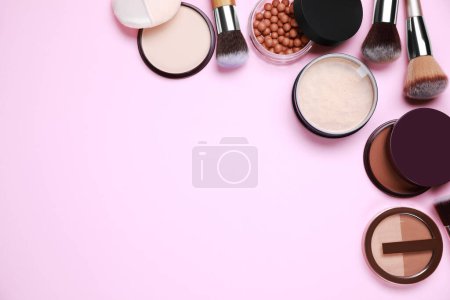 Téléchargez les photos : Différentes poudres pour le visage et pinceaux de maquillage sur fond rose, plat. Espace pour le texte - en image libre de droit