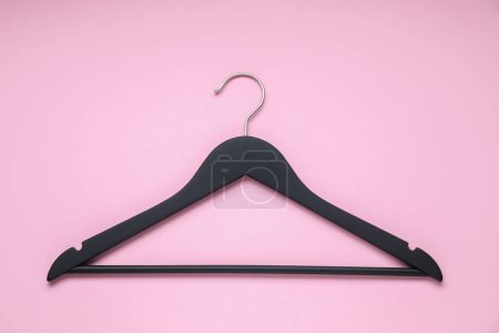 Photo for Empty black hanger on pink background, top view - Royalty Free Image
