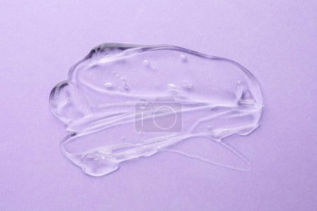 Photo for Clear cosmetic gel on violet background, top view - Royalty Free Image