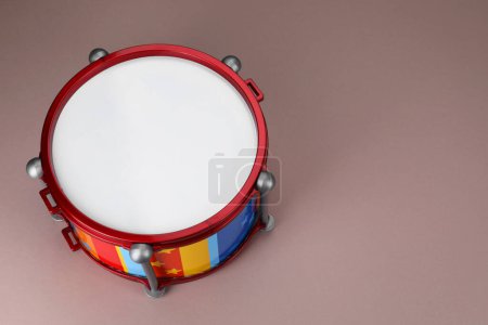 Colorful drum on dusty rose background, above view with space for text. Percussion musical instrument