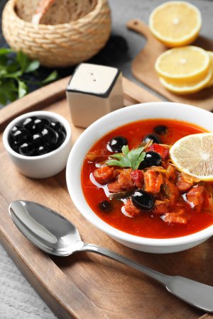Téléchargez les photos : Soupe de viande solyanka aux saucisses, olives et légumes dans un bol servi sur table grise, gros plan - en image libre de droit
