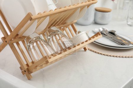 Photo for Drying rack with clean dishes on light marble countertop in kitchen, closeup - Royalty Free Image
