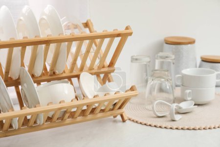 Photo for Drying rack with clean dishes on light marble countertop in kitchen - Royalty Free Image