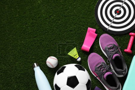 Téléchargez les photos : Différents équipements sportifs sur herbe verte, pose plate. Espace pour le texte - en image libre de droit