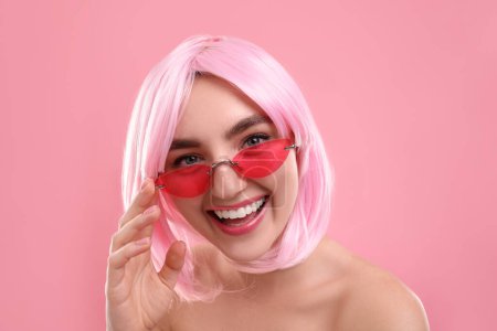 Pinkfarbener Look. Schöne Mädchen mit Perücke und heller Sonnenbrille auf farbigem Hintergrund