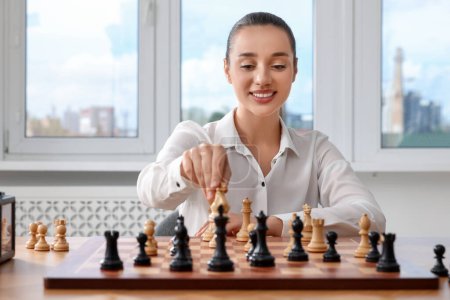 Woman playing chess during tournament at table indoors