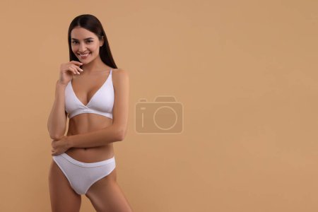 Photo for Young woman in stylish white bikini on beige background. Space for text - Royalty Free Image