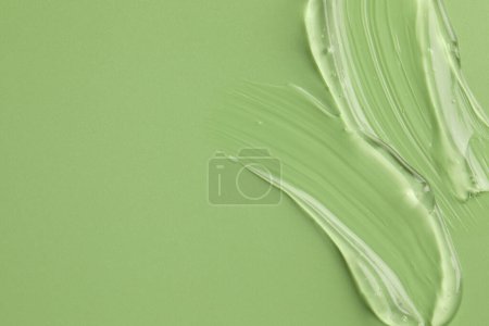 Photo for Sample of clear cosmetic gel on light green background, top view. Space for text - Royalty Free Image