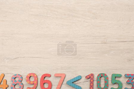 Photo for Colorful numbers and mathematical symbols on light wooden table, flat lay. Space for text - Royalty Free Image