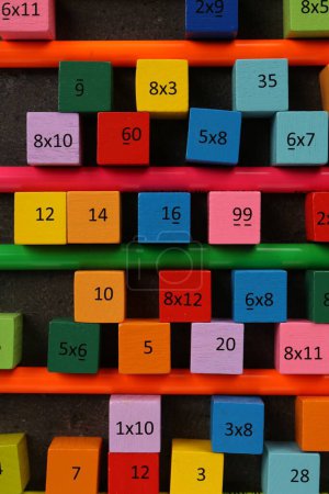 Photo for Many colorful cubes with numbers, multiplications and pencils on dark grey table, flat lay - Royalty Free Image