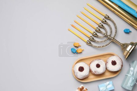 Flat lay composition with Hanukkah menorah and gift boxes on light grey background. Space for text