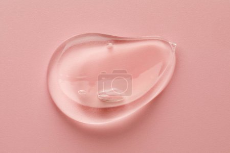 Photo for Smear of clear cosmetic gel on pink background, top view - Royalty Free Image