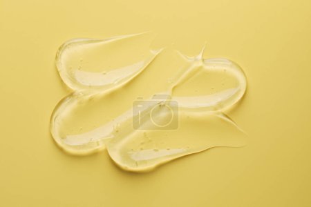 Photo for Sample of clear cosmetic gel on yellow background, top view - Royalty Free Image