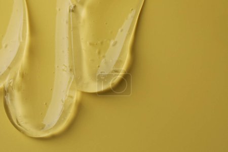 Photo for Sample of clear cosmetic gel on yellow background, top view. Space for text - Royalty Free Image
