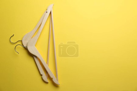 Photo for Wooden hangers on yellow background, top view. Space for text - Royalty Free Image