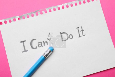 Concepto de motivación. Papel con frase cambiada de I Can 't Do It into I Can Do It borrando la letra T sobre fondo rosa, vista superior