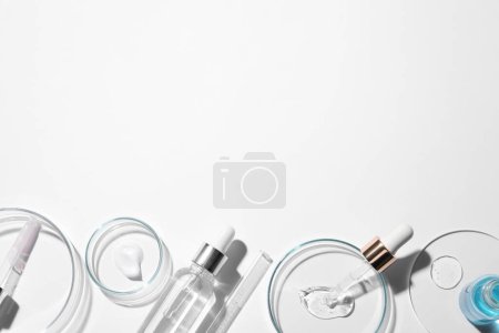 Photo for Flat lay composition with petri dishes and samples of cosmetic serums on white background. Space for text - Royalty Free Image
