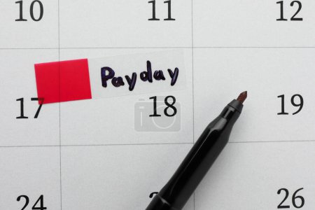 Photo for Black felt pen on calendar page with marked payday date, top view - Royalty Free Image