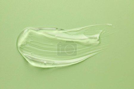 Photo for Smear of clear cosmetic gel on light green background, top view - Royalty Free Image