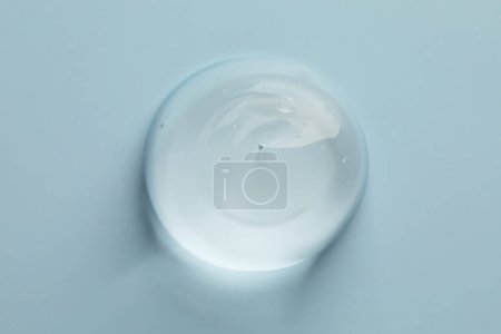 Photo for Sample of clear cosmetic gel on light blue background, top view - Royalty Free Image