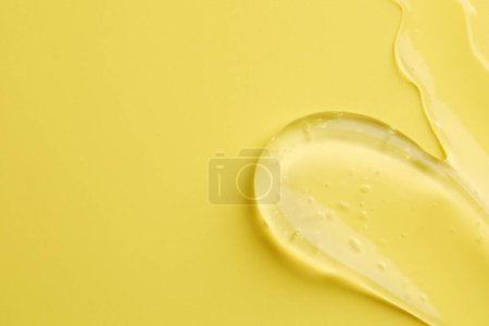 Photo for Sample of clear cosmetic gel on yellow background, top view. Space for text - Royalty Free Image