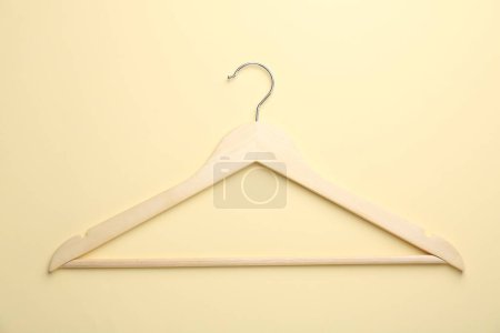 Photo for Wooden hanger on pale yellow background, top view - Royalty Free Image