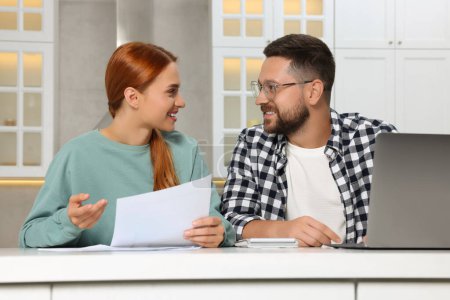 Couple doing taxes at table in kitchen