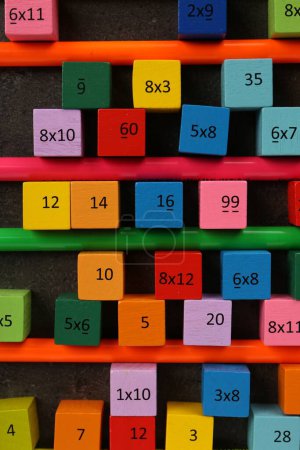 Photo for Many colorful cubes with numbers, multiplications and pencils on dark grey table, flat lay - Royalty Free Image