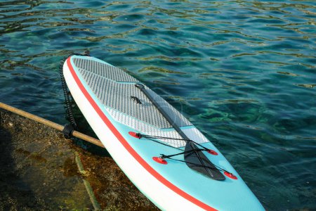 Ein SUP-Board mit Paddel am Meeresufer
