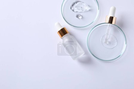 Photo for Petri dishes with samples of cosmetic serums, pipette and bottle on white background, flat lay. Space for text - Royalty Free Image