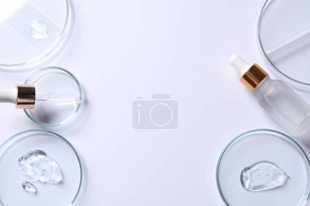 Photo for Petri dishes with samples of cosmetic serums, pipette and bottle on white background, flat lay. Space for text - Royalty Free Image
