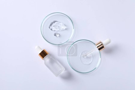 Photo for Petri dishes with samples of cosmetic serums, pipette and bottle on white background, flat lay - Royalty Free Image
