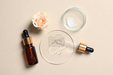 Photo for Bottle of cosmetic serum, petri dishes with samples and flower on beige background, flat lay - Royalty Free Image