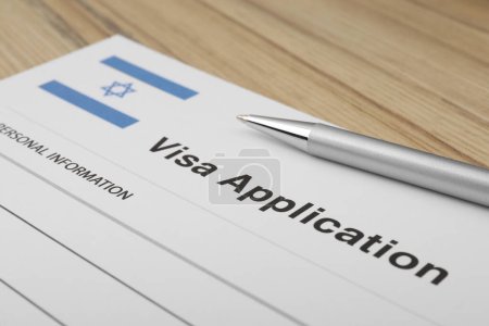Einwanderung nach Israel. Visum-Antragsformular und Stift auf Holztisch, Nahaufnahme