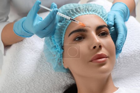 Arzt gibt junge Frau in Klinik Gesichtsinjektion Schönheitschirurgie