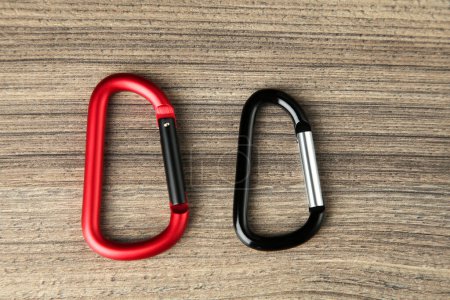 Photo for Two metal carabiners on wooden table, flat lay - Royalty Free Image