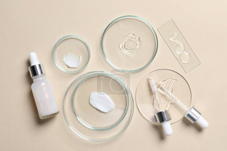 Photo for Bottle of cosmetic serum and petri dishes with samples on beige background, flat lay - Royalty Free Image