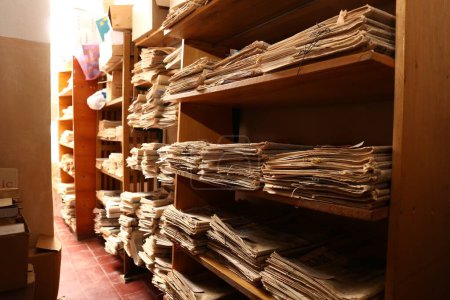 Téléchargez les photos : Collection de vieux journaux sur les étagères de la bibliothèque - en image libre de droit