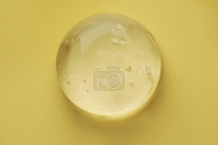 Photo for Sample of clear cosmetic gel on yellow background, top view - Royalty Free Image