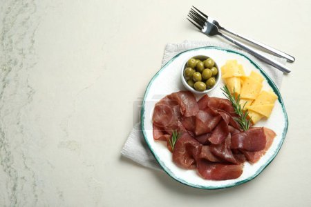 Photo for Delicious bresaola, cheese, olives and rosemary served on light textured table, top view. Space for text - Royalty Free Image
