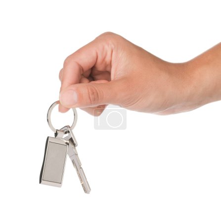 Woman holding key with metallic keychain on white background, closeup